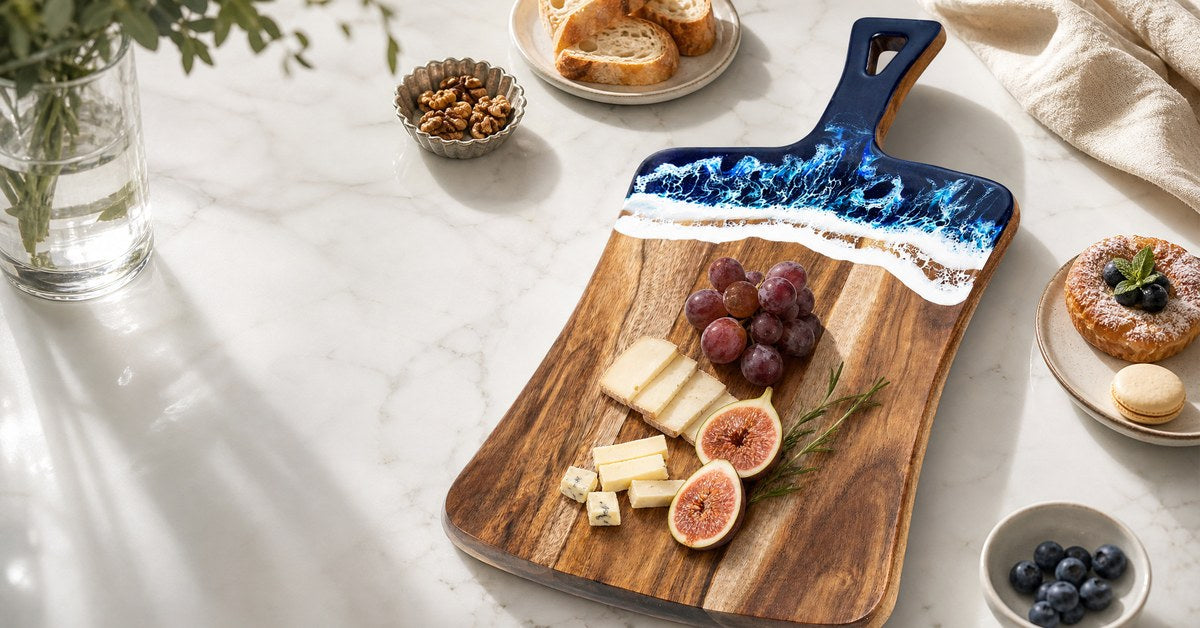 Acacia wood and resin serving board styled with cheese fruit and bread on a bright kitchen counter