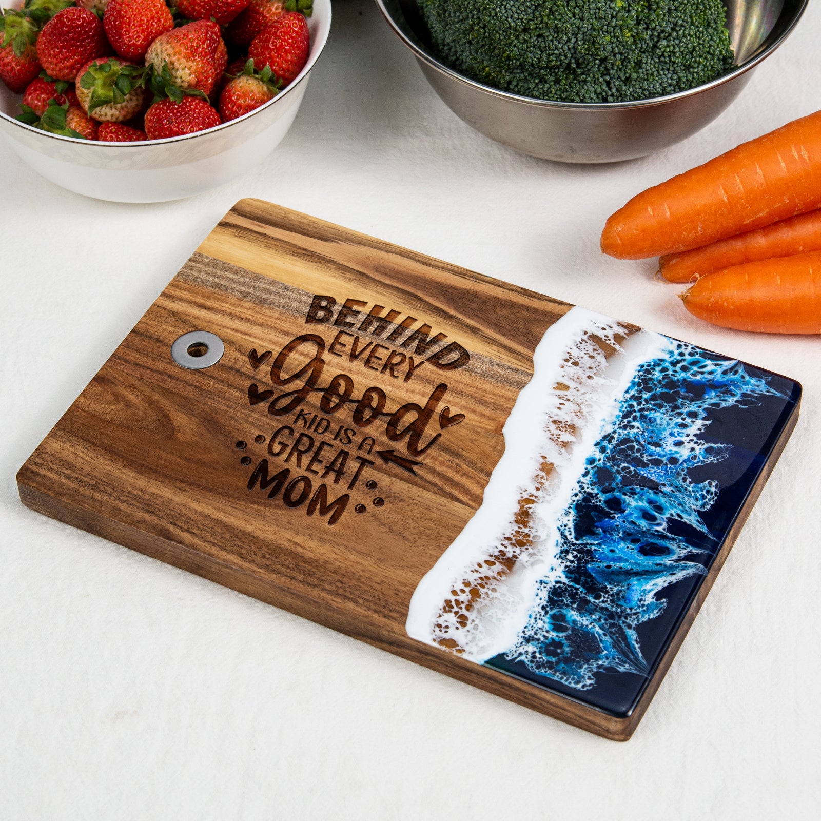 Small blue resin cutting board engraved with behind every good kid is a good mom quote