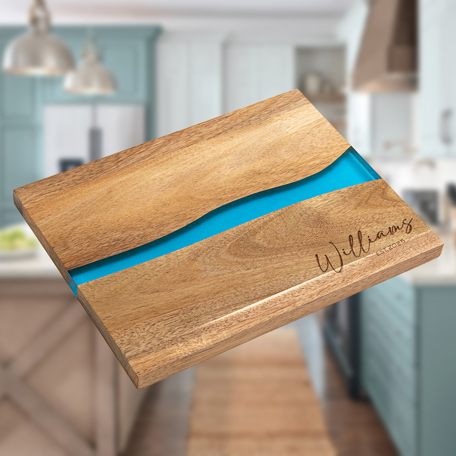 Flat lay view of personalized epoxy resin cutting board with family name and EST year laser engraved on acacia wood blue river inlay
